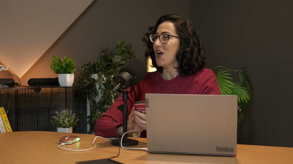 Two people recording a video podcast on microphones in a modern studio workspace